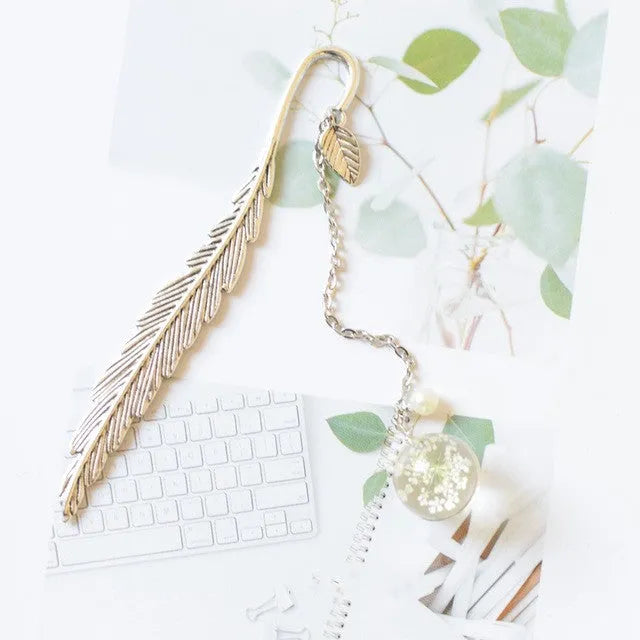 Dried flower specimen encased in metal alloy bookmark pendant measuring 12cm by 2cm