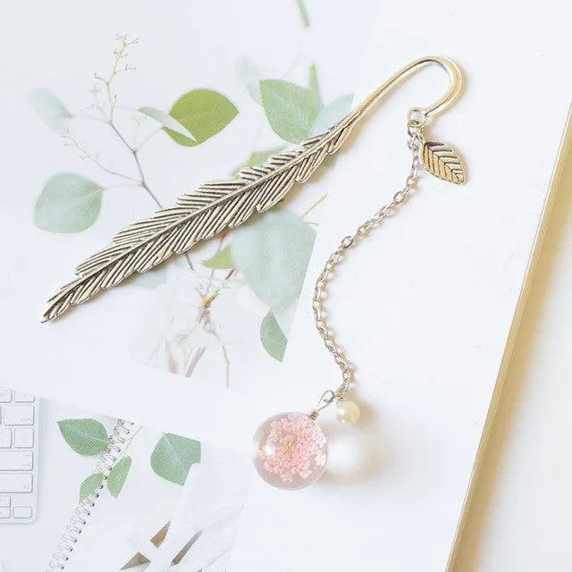 Dried flower specimen encased in metal alloy bookmark pendant measuring 12cm by 2cm