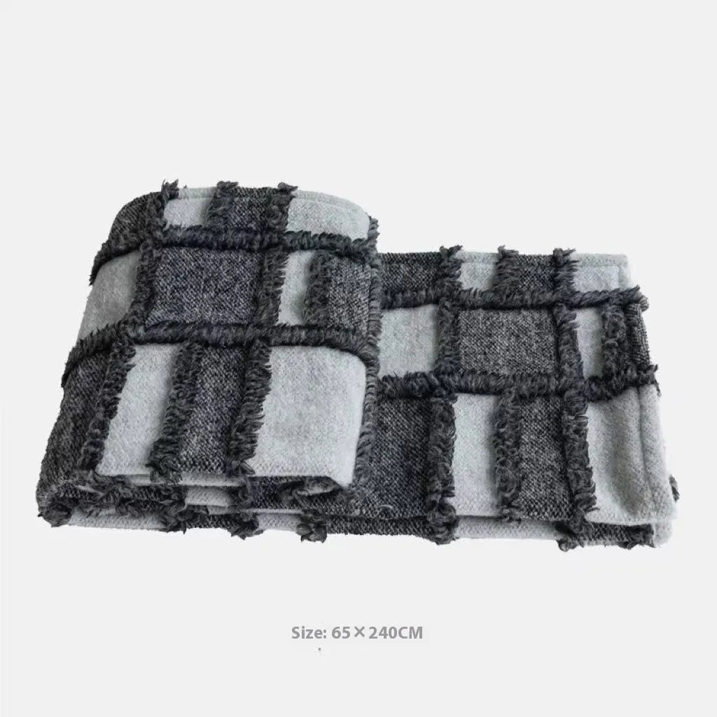 Grey and white plaid bed runner blanket and matching pillow on a double bed.