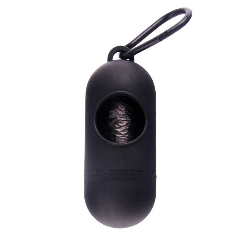 A compact black dog poop bag holder with a side hook and Velcro strap, shown next to a roll of waste bags.