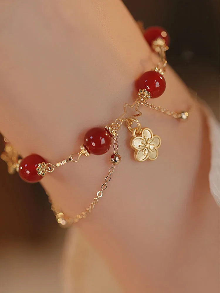 Handmade red agate double layer bracelet with floral peach blossom design on a white background.