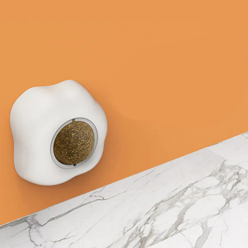 Soft plush catnip ball toy in egg shapes stuck to a wall for interactive cat play.