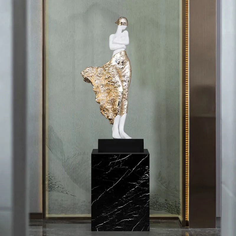 Tall modern minimalist sculpture ornament in rose gold finish on a wooden surface.