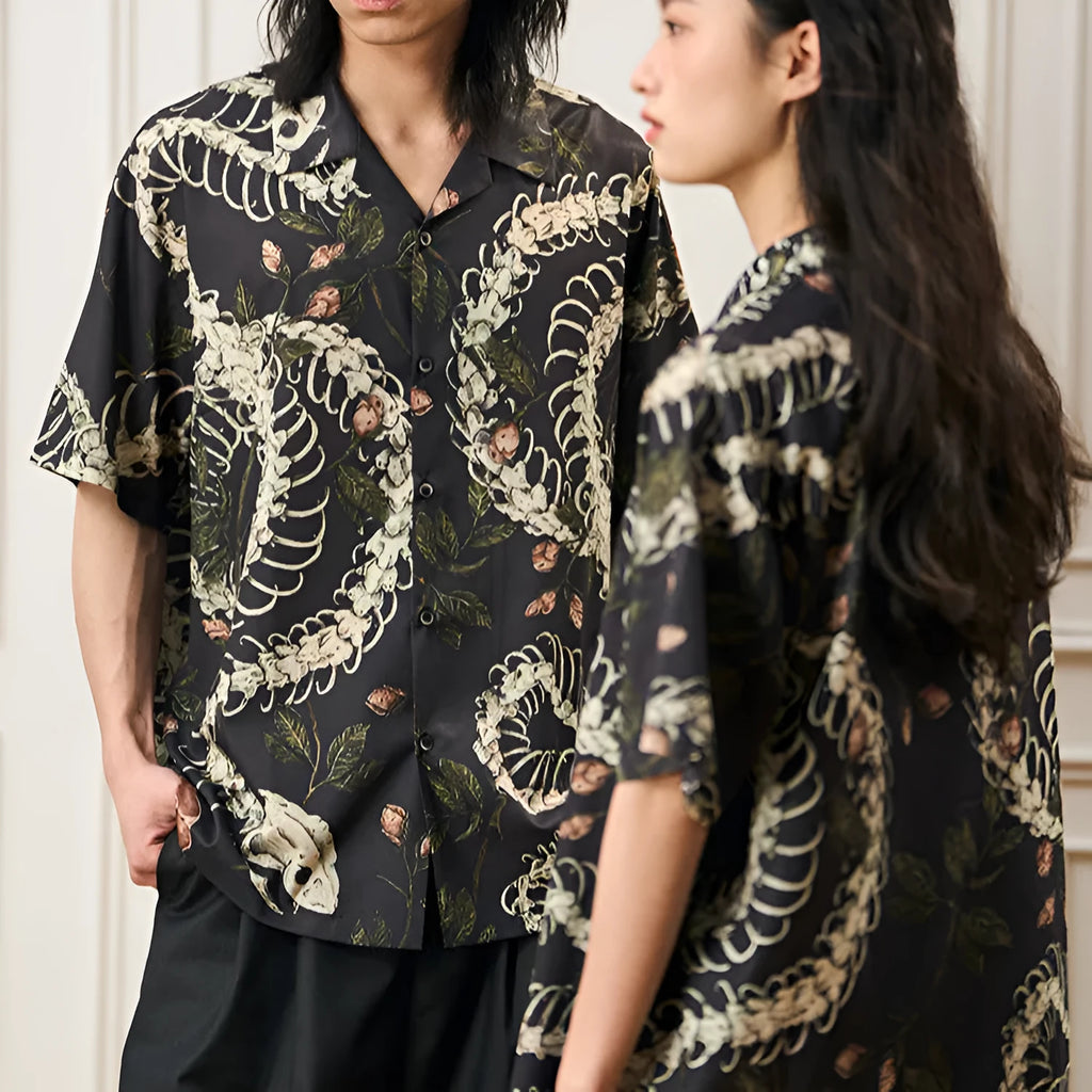 Man wearing a loose fit Cuban collar shirt with a printed snake bone and floral pattern in a summer setting.