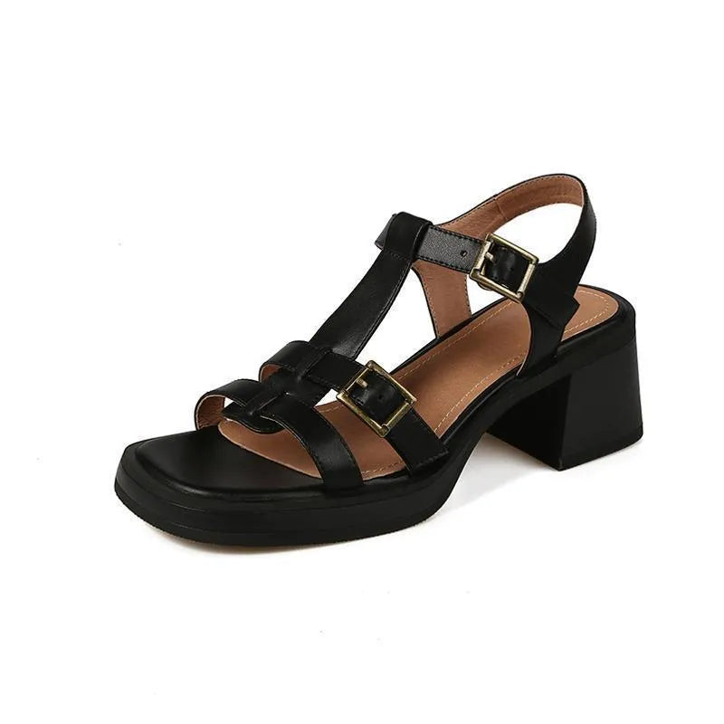Women's black retro sandals with T-shaped buckle, chunky heel, and square open toe on a plain background.