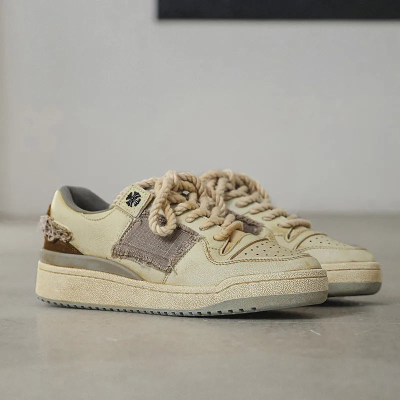 Beige low-top skateboard shoes with round toe and front lace-up closure on a flat rubber sole.