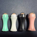 Portable black volcanic stone roller for oily skin control on a pink background.