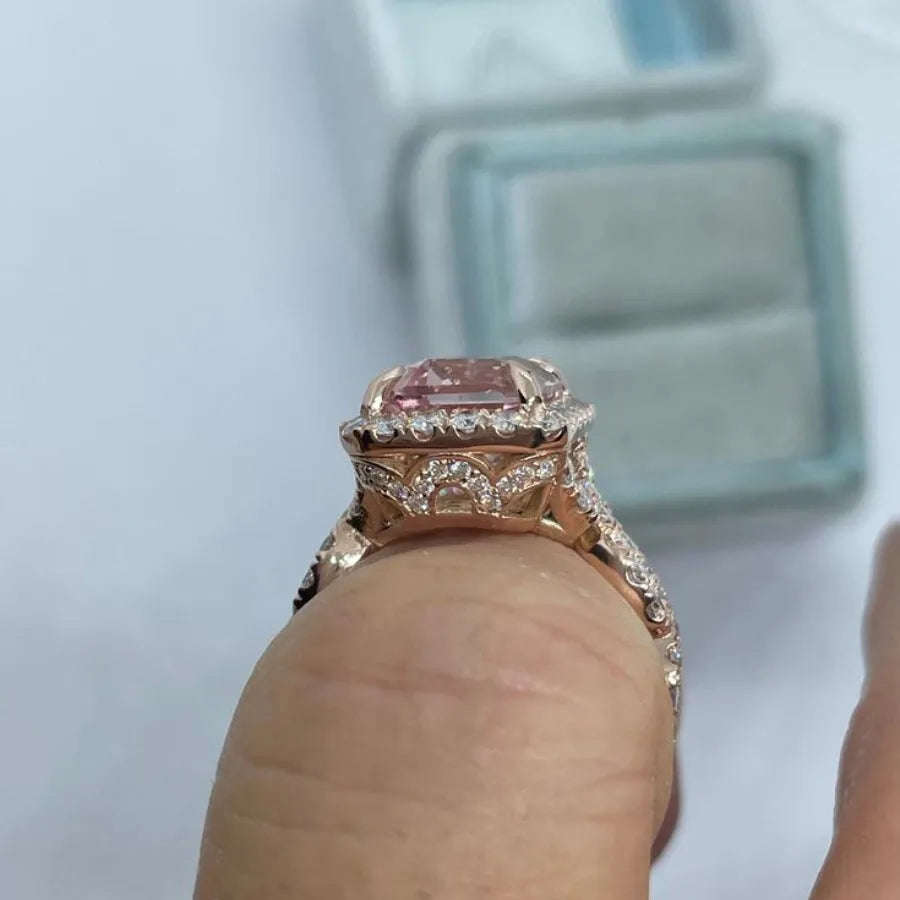 A geometric-shaped rose gold alloy ring on a plain background.