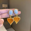 Silver textured oval love heart stud earrings in purple, red, green, and yellow white on a jewellery card.