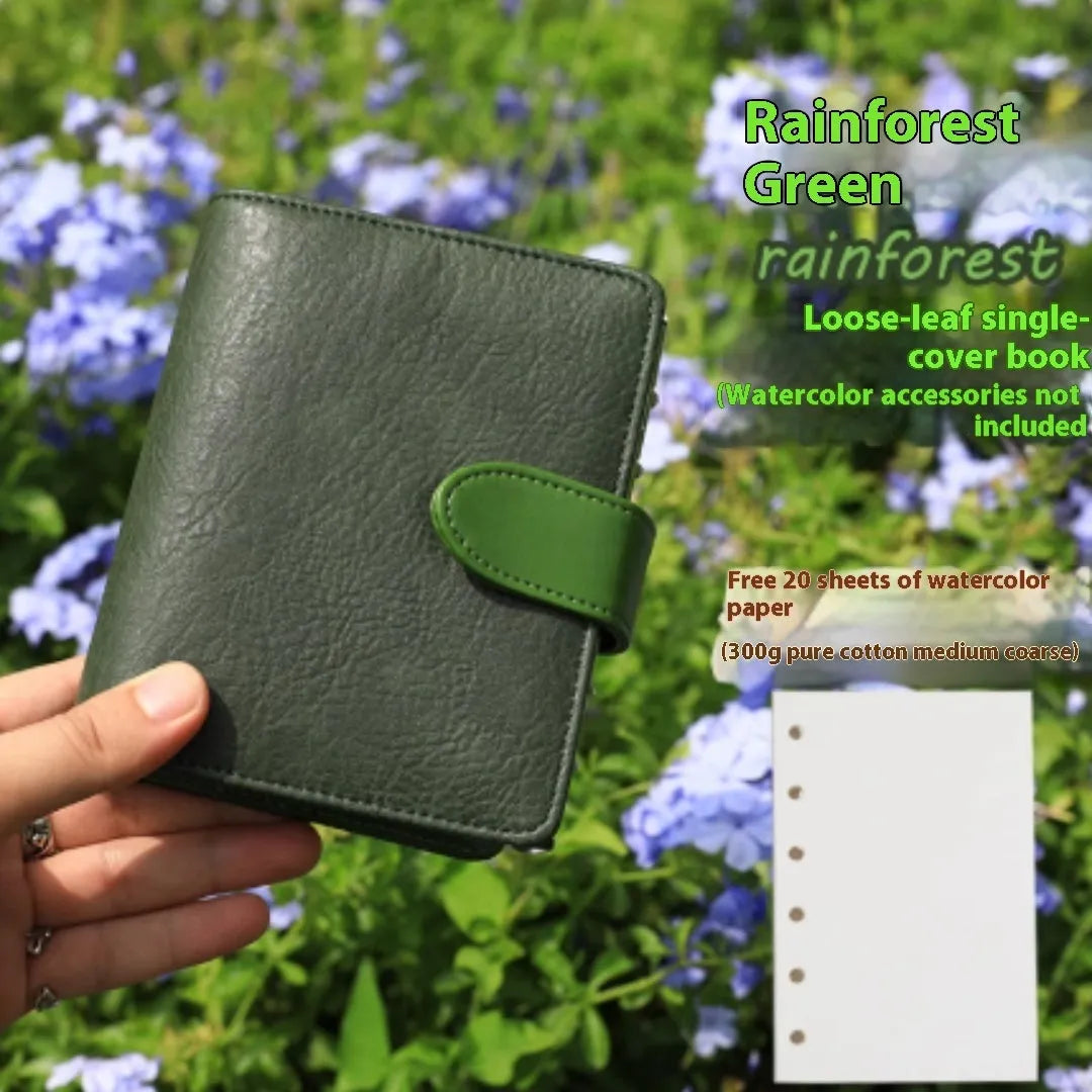 A7 format loose-leaf watercolour notebook in green, open to show removable pages suitable for painting.