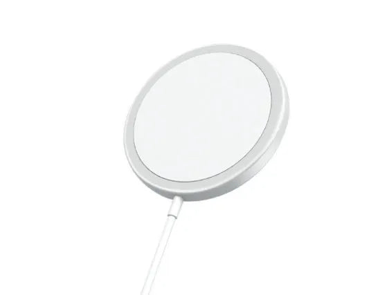 Silver metal Magsafe wireless charger for iPhone on a desk.