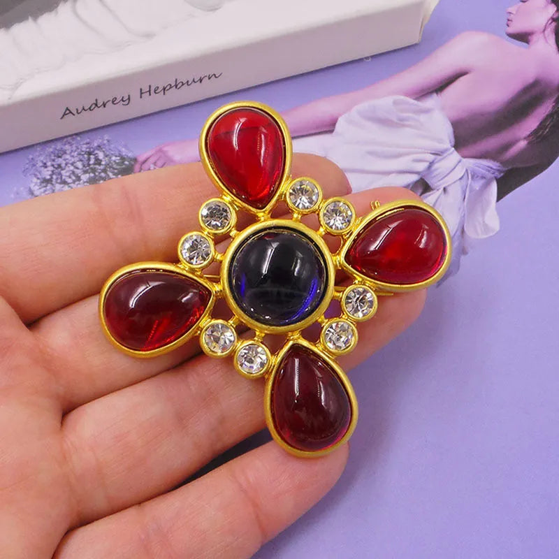 Close-up of a vintage medieval baroque cross brooch with crystals, made from zinc alloy.