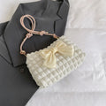 Women's horizontal square canvas handbag with single shoulder strap in black colour showing internal phone pocket