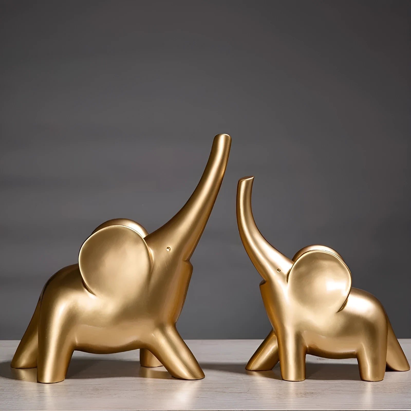 Modern minimalist solid resin elephant ornament in rose gold or white finish on a shelf.