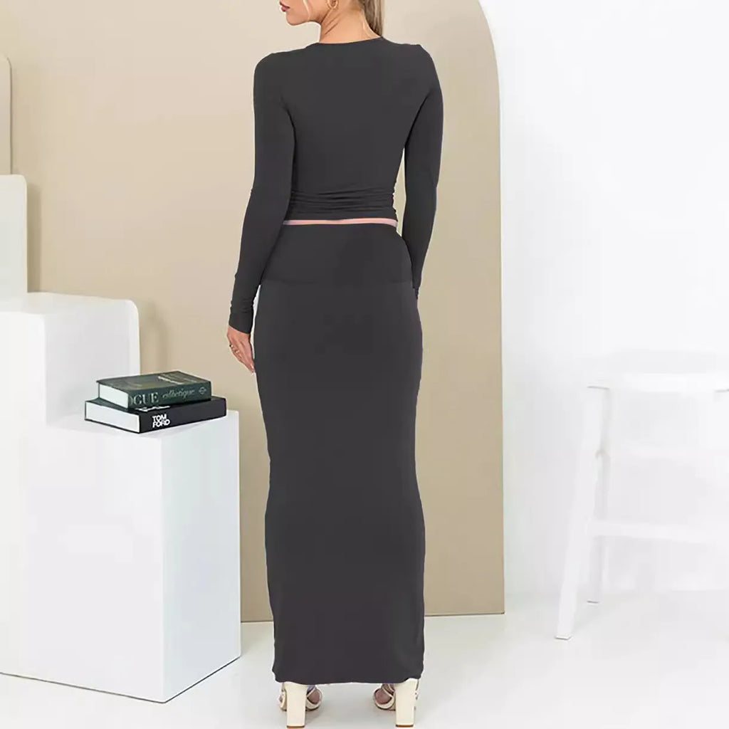 Women's black two-piece autumn suit with exposed navel top and long skirt.