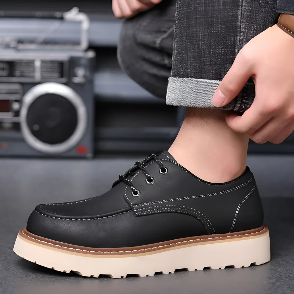 Men's black retro Martin boots with round toe and rubber sole showing height-increasing mid heel