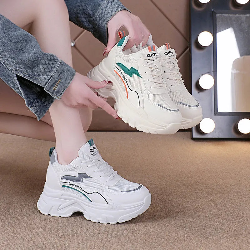 Women's white and beige height increasing dad shoes with cross straps and rubber sole.