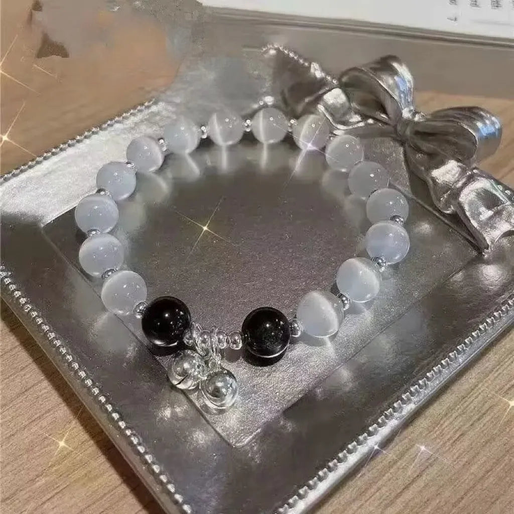 Close-up of a drop-shaped glass butterfly bracelet with round coloured beads on a wrist.