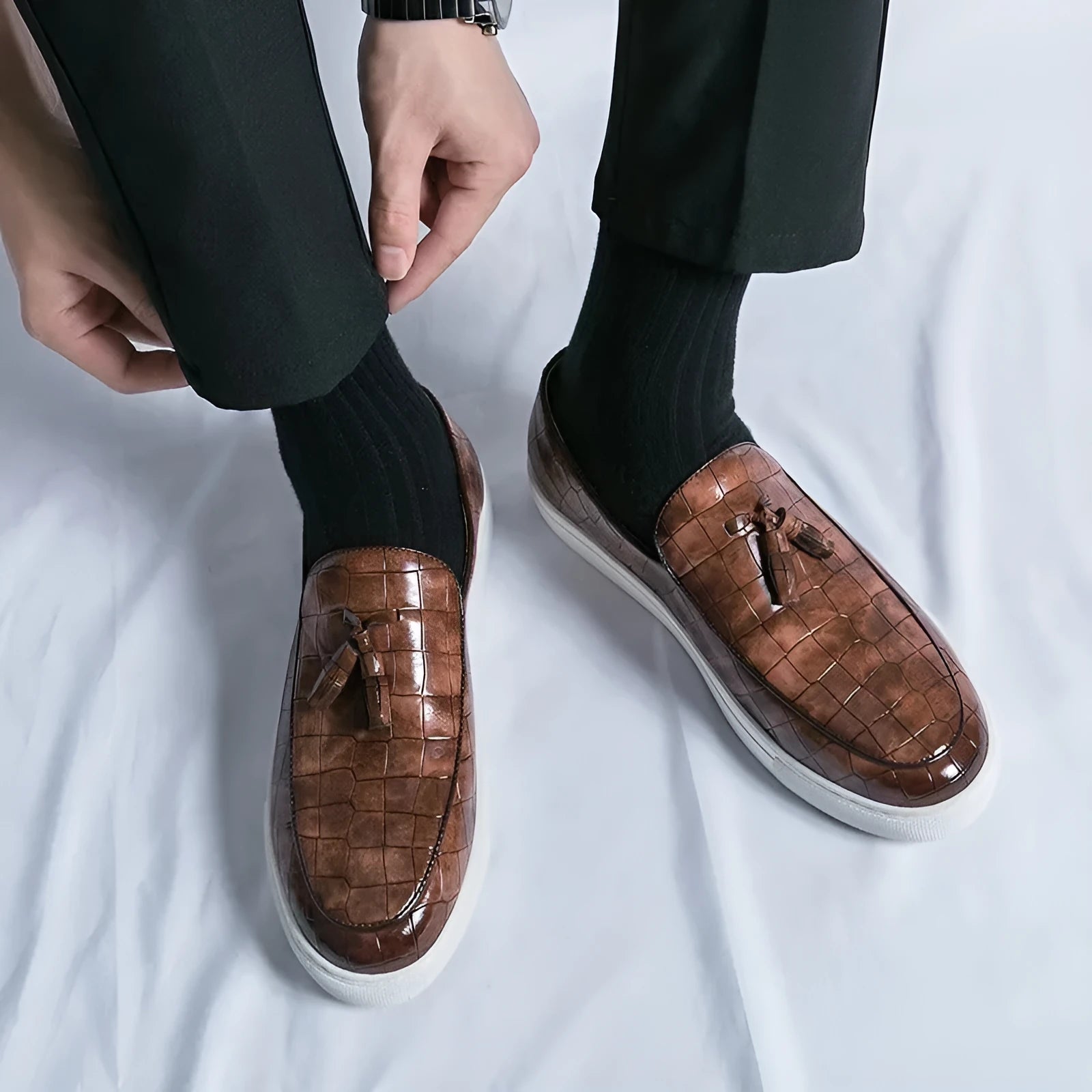 Men's brown artificial PU leather slip-on sneakers with a tassel detail on the round toe.