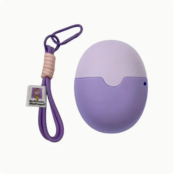 Removable silicone roller ball cream applicator in blue with lanyard next to pink and green versions