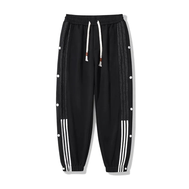 Man wearing loose grey sweatpants with ankle ties and a high waist.