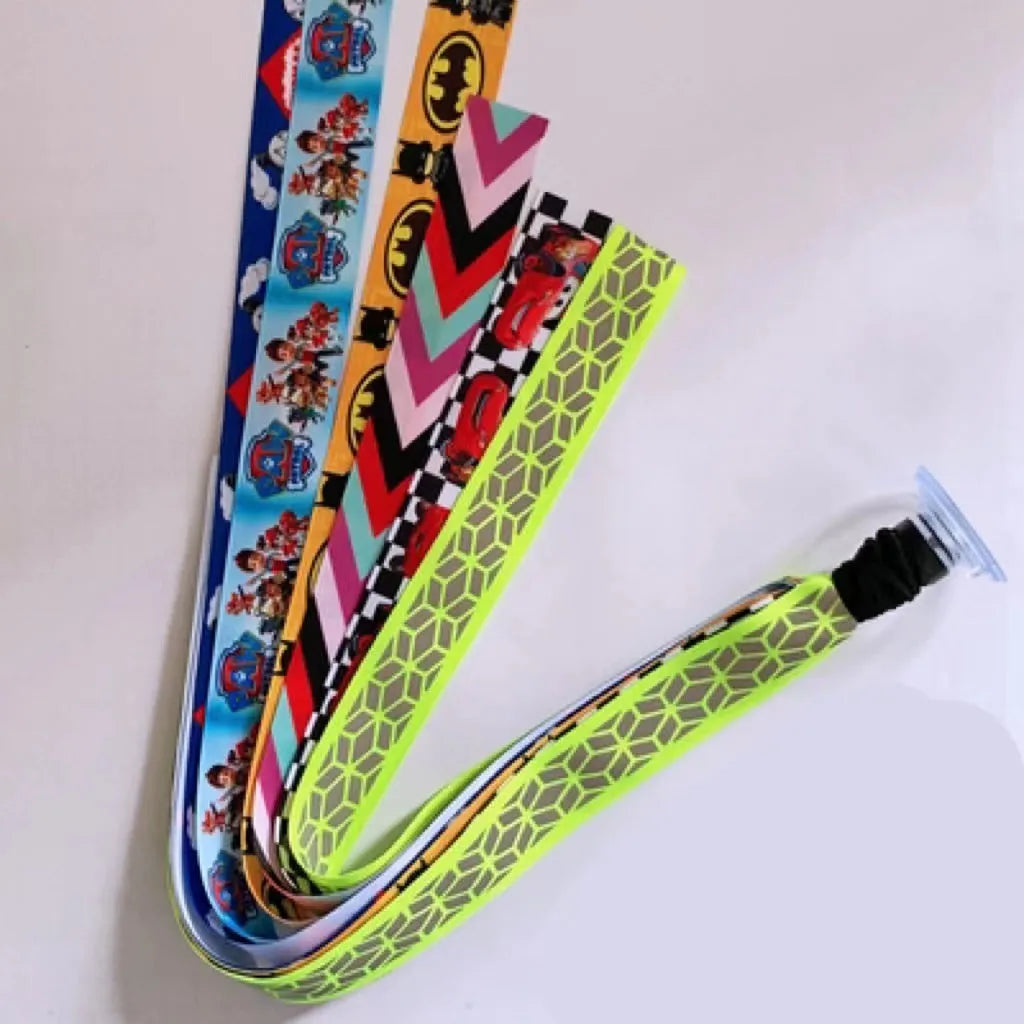 Colourful fabric helmet streamers for children's roller skating and ski helmets, shown in apricot, red, and grey.