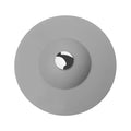 UFO-style silicone press sink drain cover in blue on a white basin, modern minimalist design