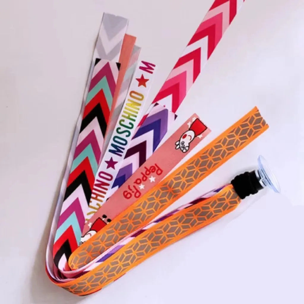 Colourful fabric helmet streamers for children's roller skating and ski helmets, shown in apricot, red, and grey.