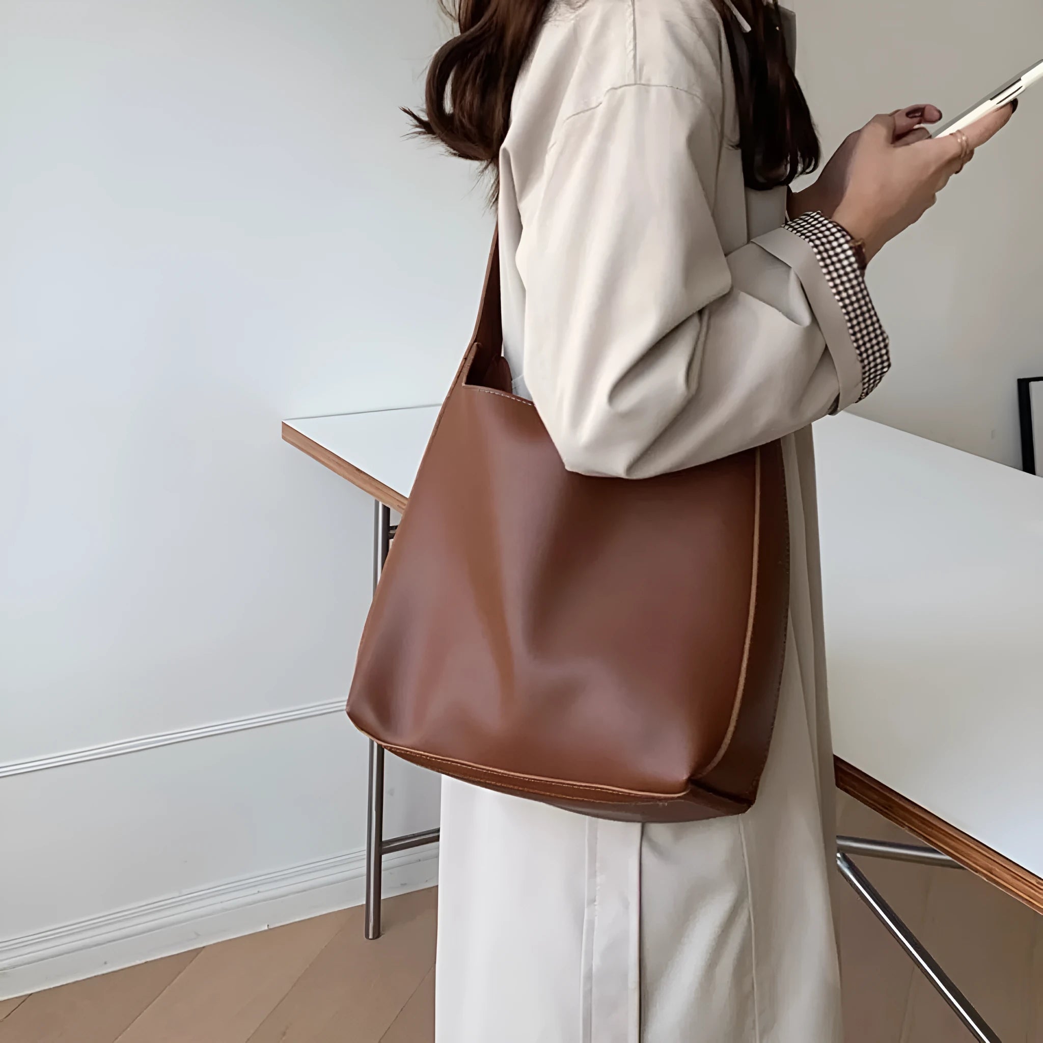 Two women's soft PU leather shoulder bags with swing threads, one black with ribbon and one brown with packet design