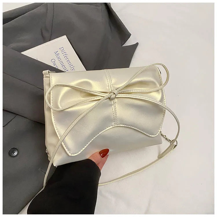 Women's black underarm bag in horizontal square shape showing sandwich pocket design and crossbody strap