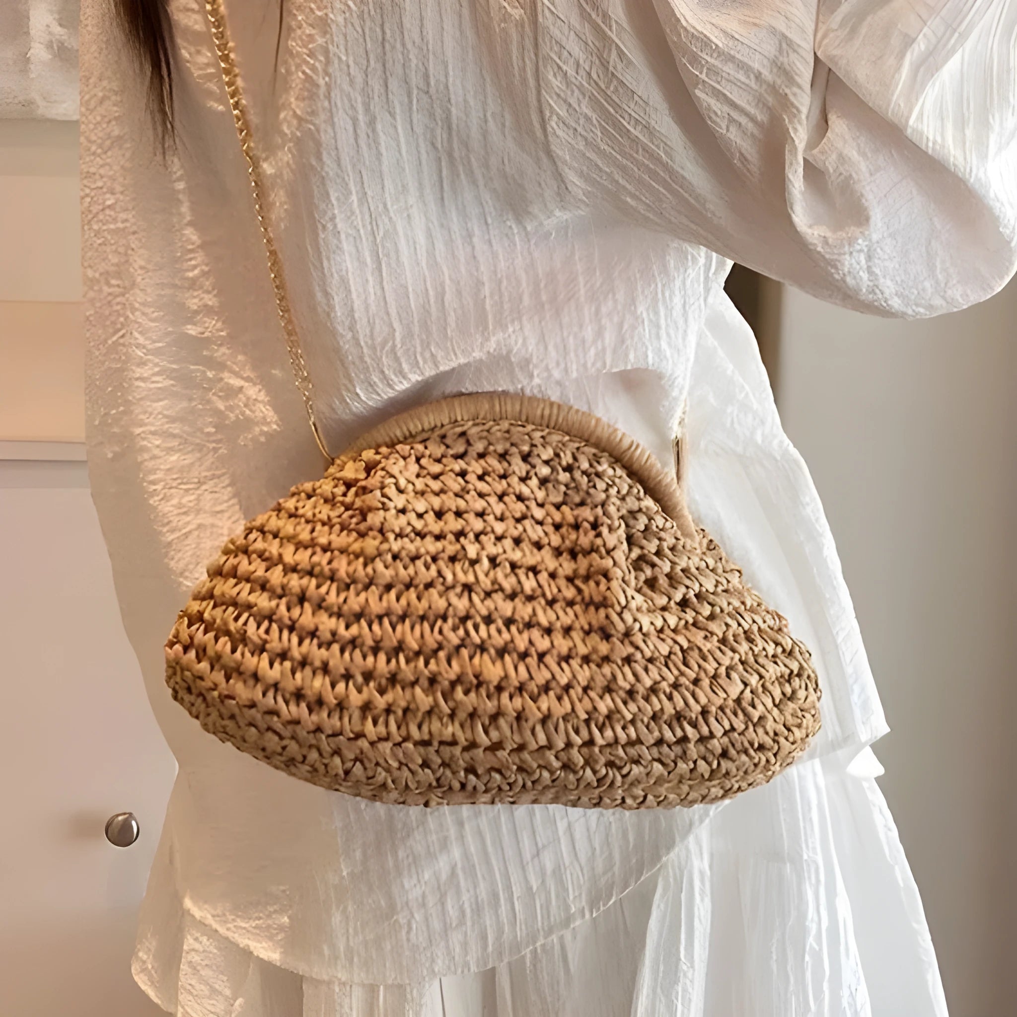 Women's straw beach bag with chain trim in khaki colour, showing shell shape and shoulder strap