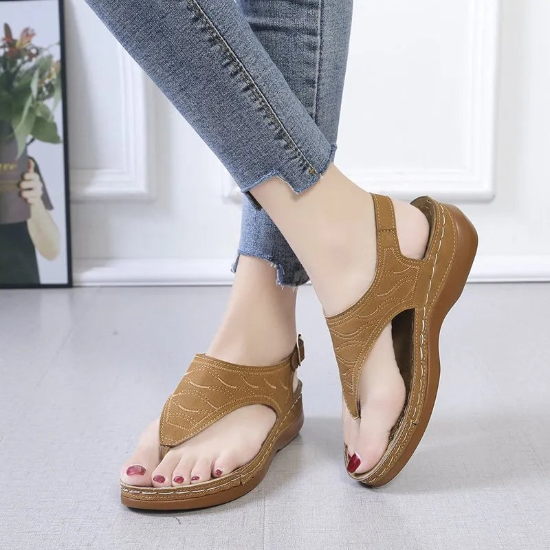 Women's wedge heel flip flop sandals in black with an adjustable buckle strap on the back.