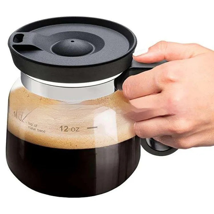 Transparent borosilicate glass pour-over coffee maker with a black silicone cover on a kitchen counter.