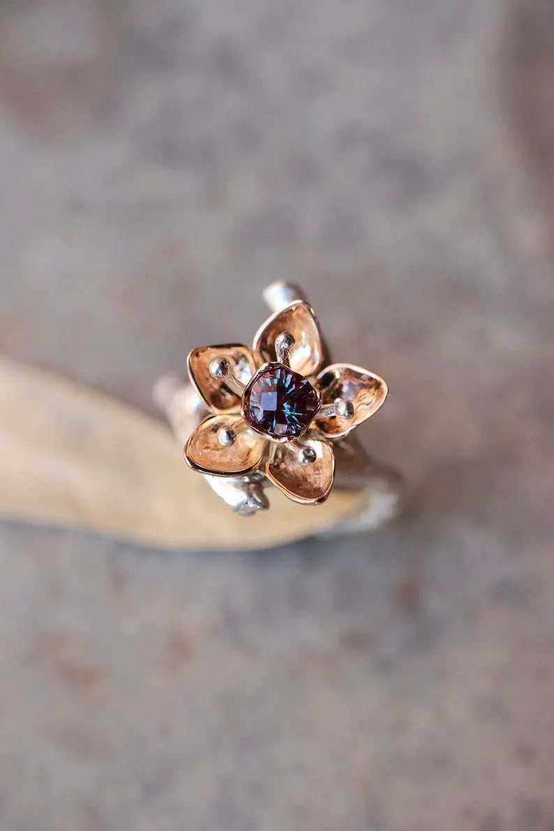 Silver two-tone floral design women's alloy ring on a simple geometric band.