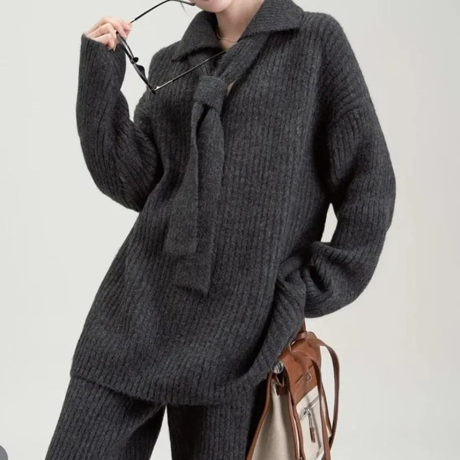 Beige sweater suit two-piece set with a knitted top and casual trousers on a hanger.