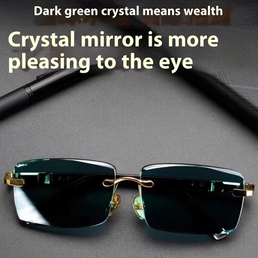 A pair of dark green frameless crystal sunglasses with a gold-tone temple arm on a case.