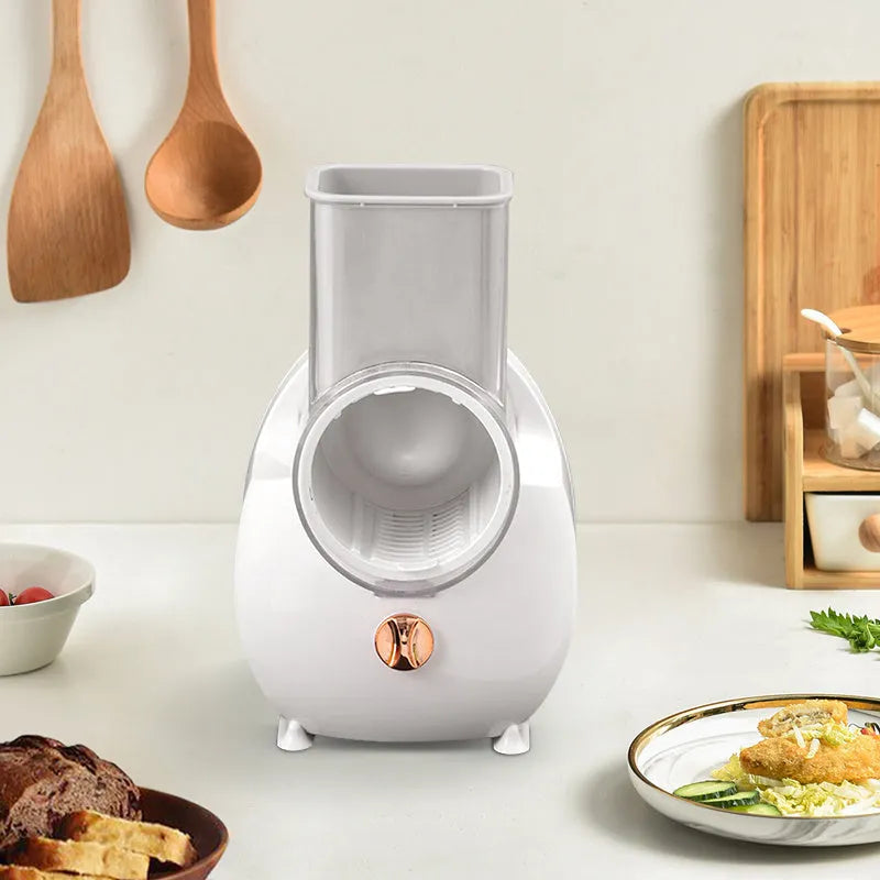 White and green electric vegetable slicer with suction base, feeding port, and multiple blades.