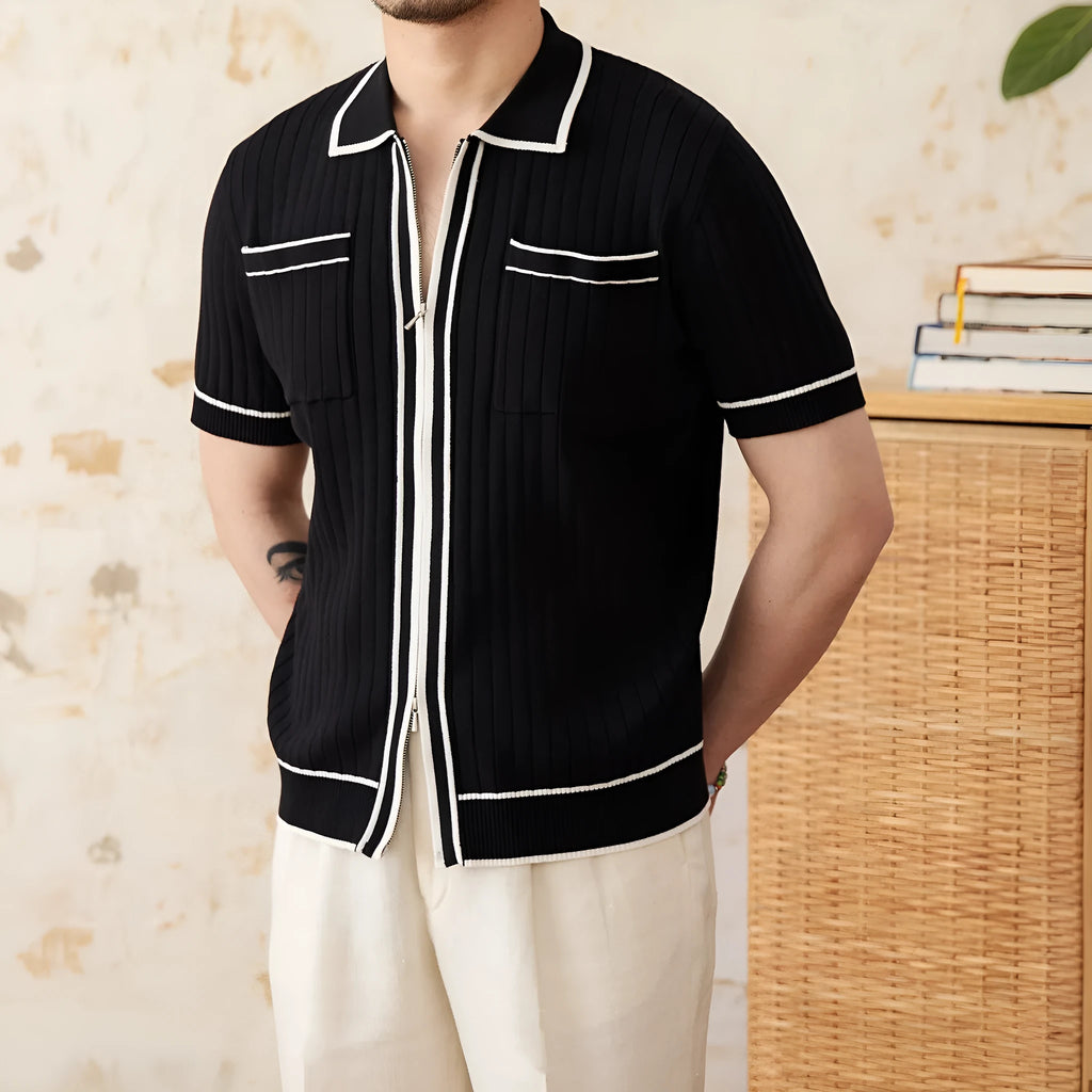 Man wearing a slim fit black knitted polo shirt with a lapel collar and short sleeves.
