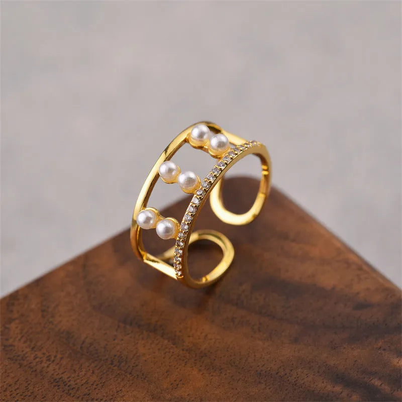 Gold geometric open fashion ring for women on a plain background.