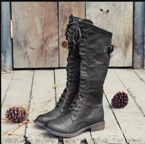 Women's black high leg boots with a round toe and low chunky heel on a plain background