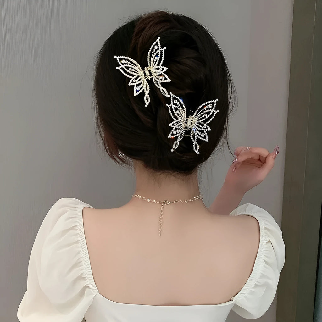 Butterfly-shaped hair clip with metal alloy construction and decorative rhinestone or pearl elements