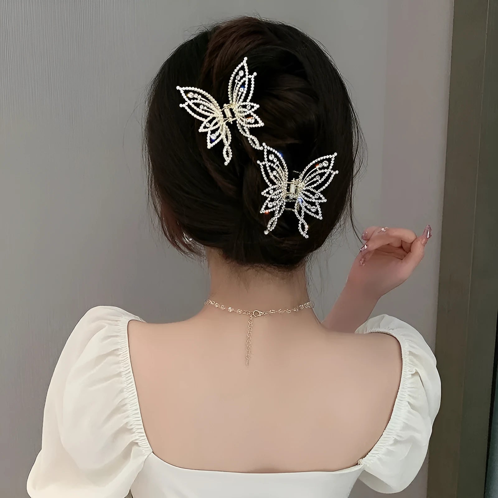 Butterfly-shaped hair clip with metal alloy construction and decorative rhinestone or pearl elements