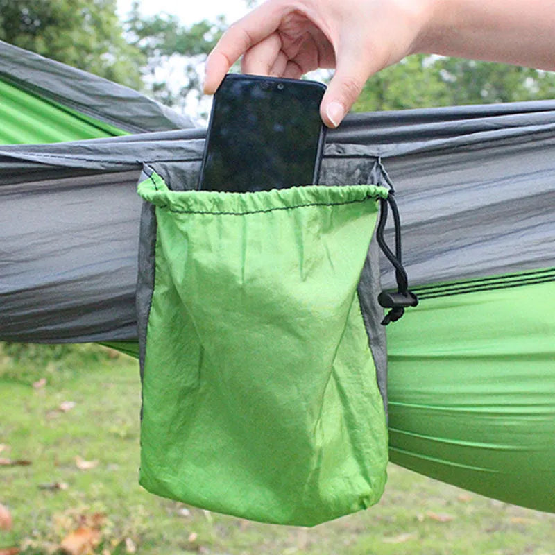 Blue parachute nylon camping hammock hung between two trees, showing its full 270cm length.