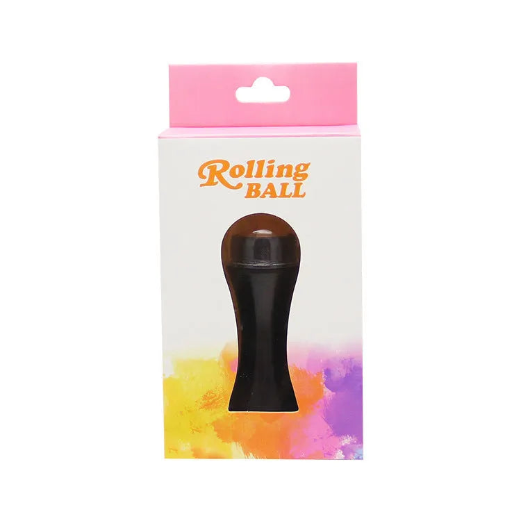 Portable black volcanic stone roller for oily skin control on a pink background.