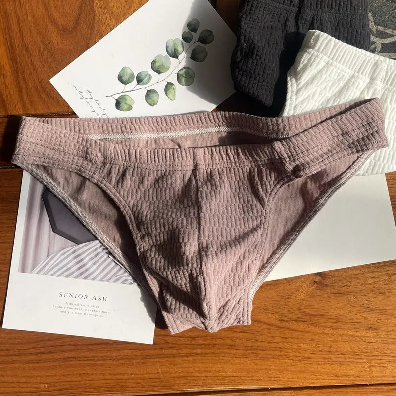 Men's solid colour cotton triangle briefs in apricot, shown from the front on a mid-waist fit model.