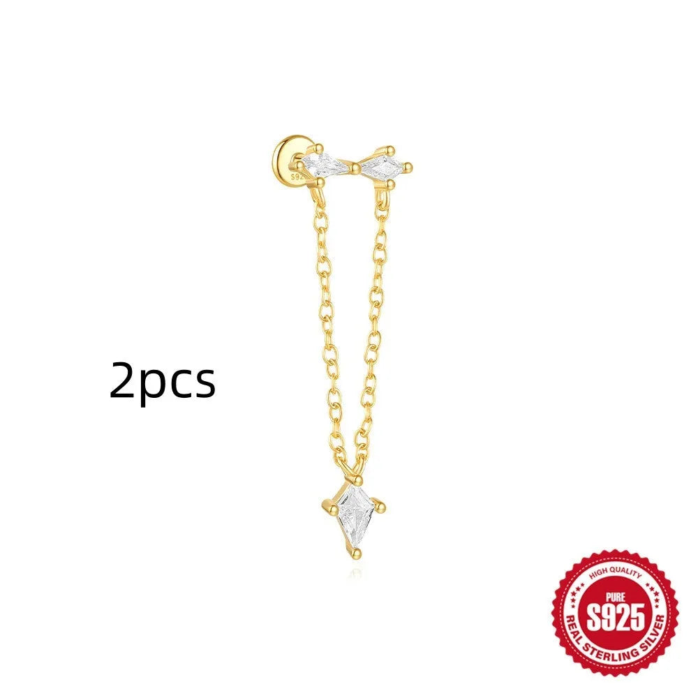 Geometric kite-shaped sterling silver stud earrings with rhinestones and a gold chain tassel.