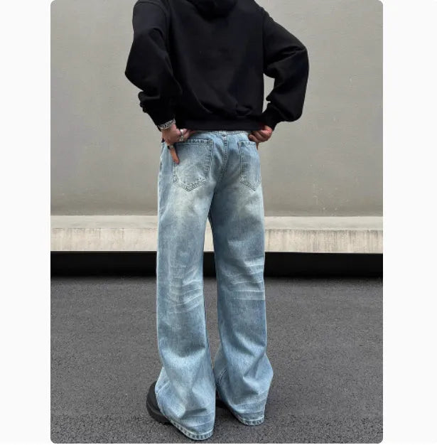 Men's blue straight leg jeans with whisker washing and flared leg style on medium-high waist