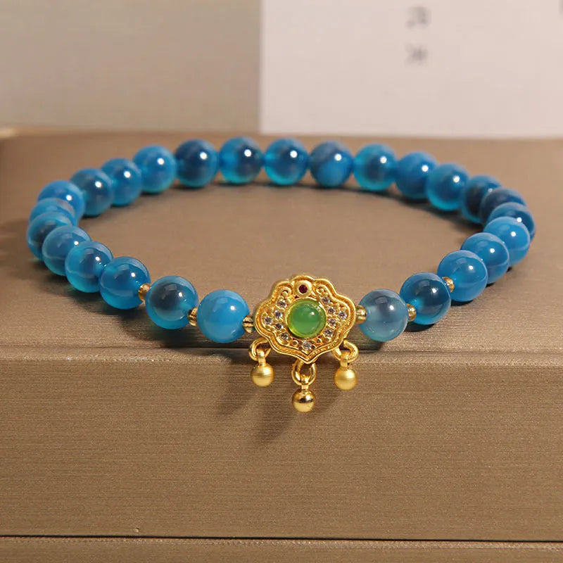 Blue sugar heart agate safety lock pendant on a crystal women's bracelet with alloy-set stones.