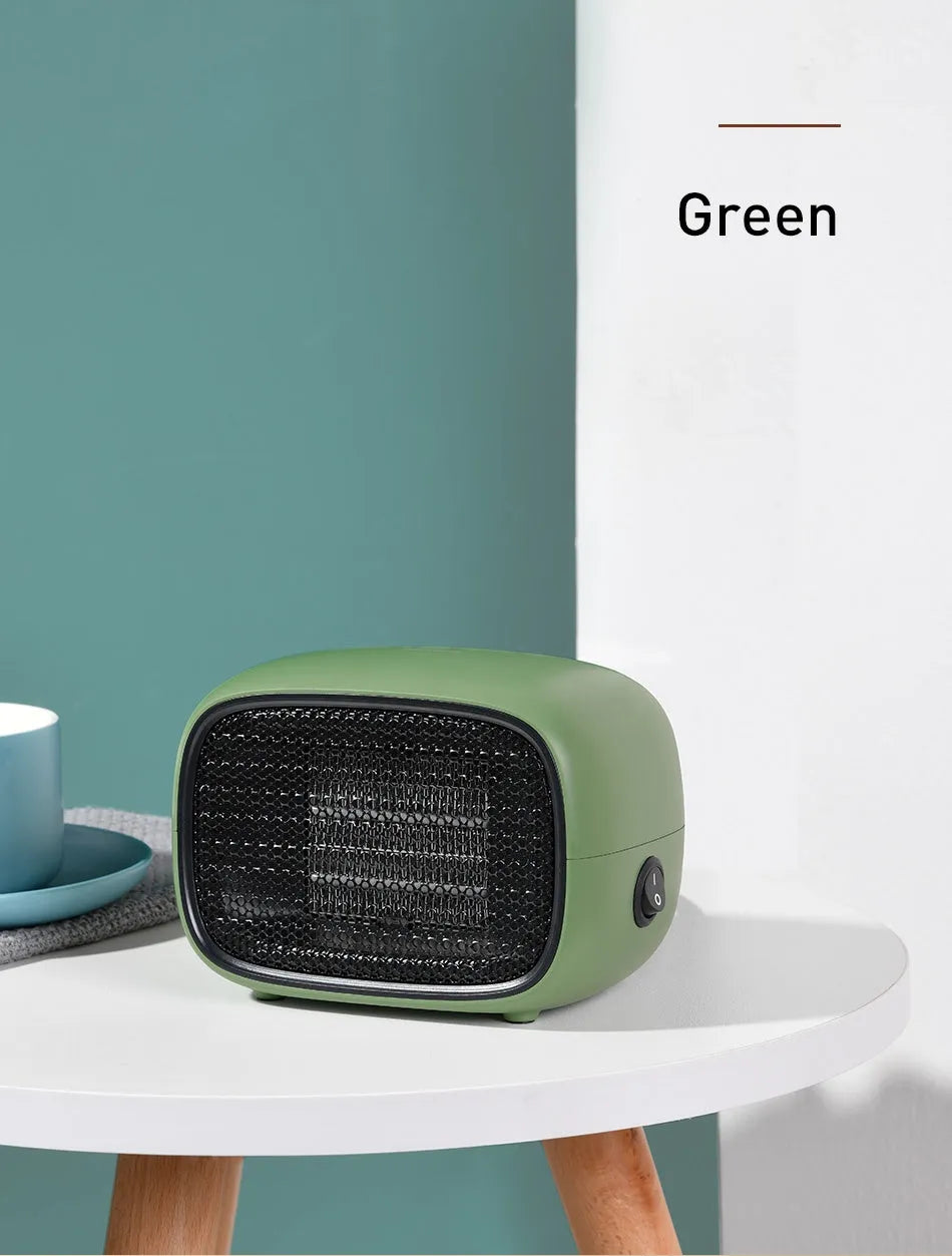 Green mini PTC ceramic fan heater showing compact size and metal mesh front grille.