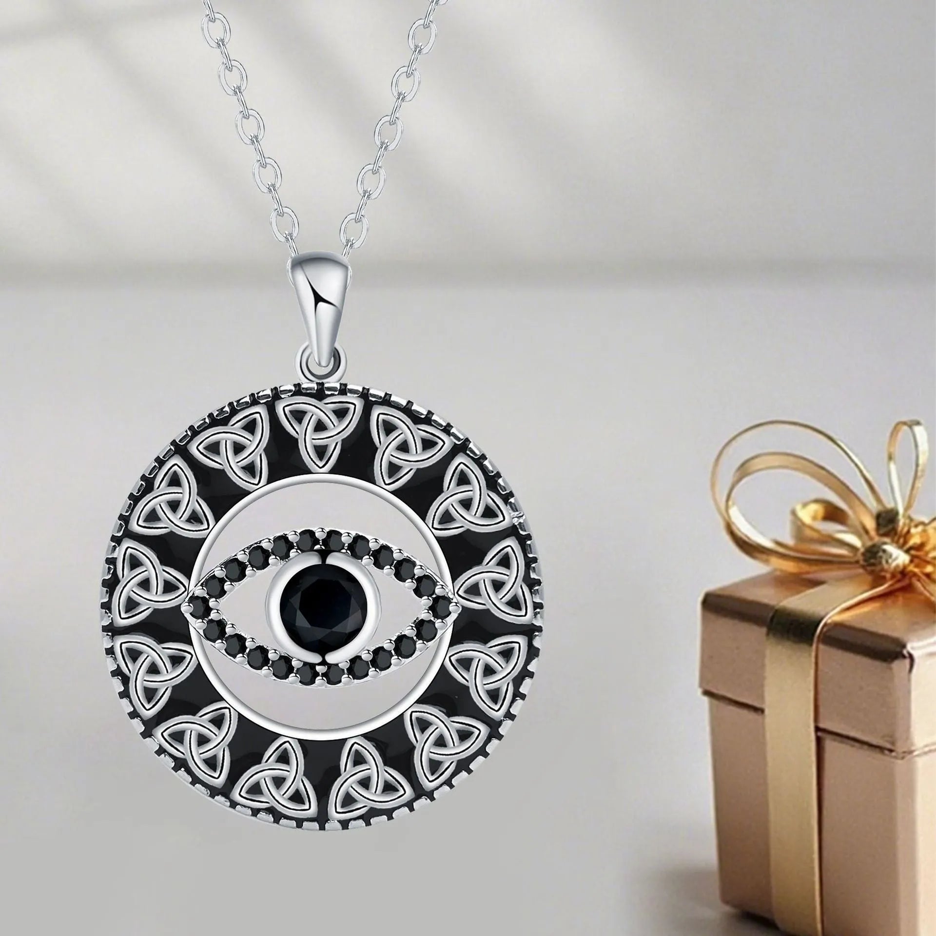 Close-up of a copper Devil's Eye pendant necklace with an electroplated finish on a matching cross chain.